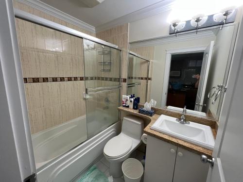 a bathroom with a toilet and a sink and a shower at Private suite 1 bed 1 bath 15 mins YVR and downtown 舒适安静 in Vancouver