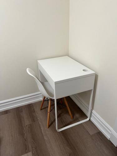 a white desk and a chair next to a wall at Private suite 1 bed 1 bath 15 mins YVR and downtown 舒适安静 in Vancouver