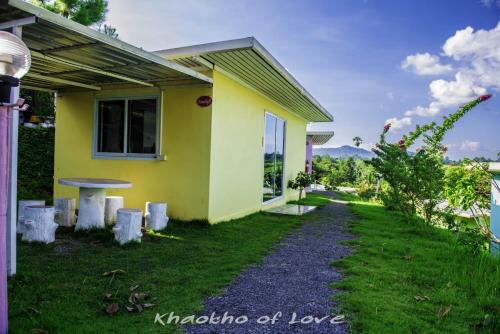a yellow house with a pathway leading to it at เขาค้อออฟเลิฟ in Khao Kho