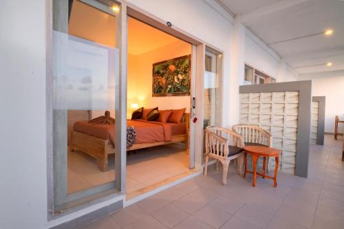 a bedroom with a bed and a table and chairs at Sau Bali Beach House Canggu in Canggu