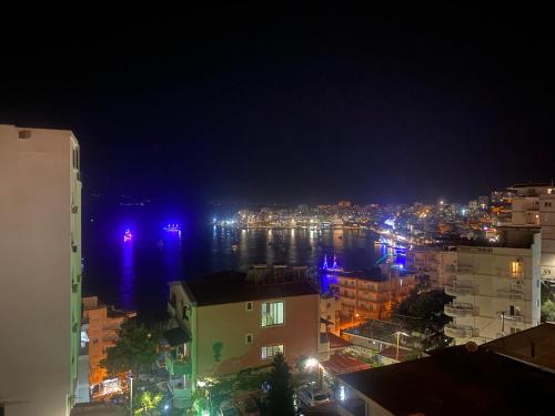 a view of a city at night with the water at Blue Breeze Attic Apartments in Sarandë