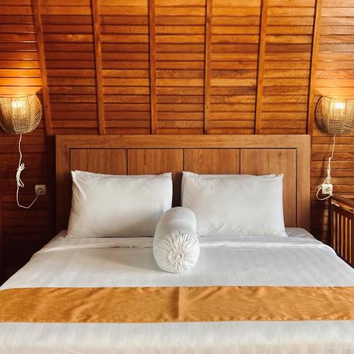 ein Bett mit zwei weißen Kissen und zwei Lampen in der Unterkunft Wailanga Resort in Ternate