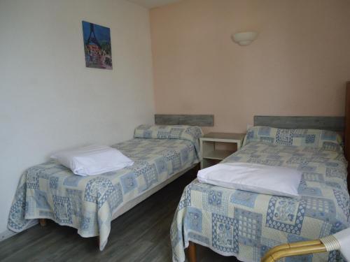 una habitación con dos camas en una habitación en Studios La Gemme, en Dax