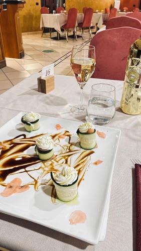 a table with a plate of food and a glass of wine at Hotel La Torretta in Castel San Pietro Terme