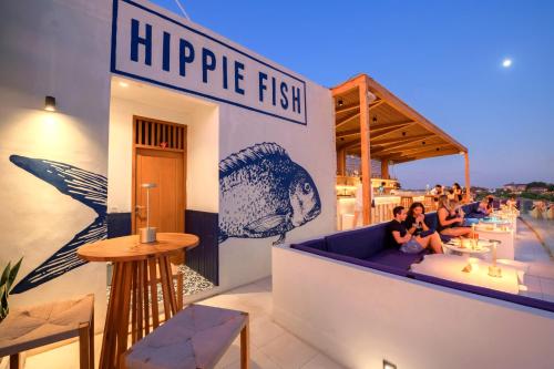 a restaurant with people sitting on a couch on a rooftop at Sau Bali Beach House Canggu in Canggu