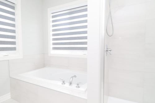 a white bathroom with a sink and a window at Tranquil Nest By The Airport in Ottawa