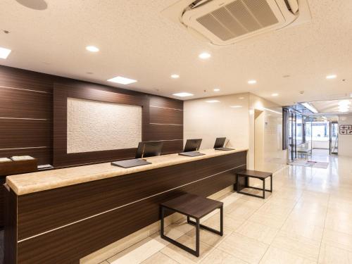 a lobby with a reception desk with two computers on it at Hotel Wing International Shizuoka in Shizuoka
