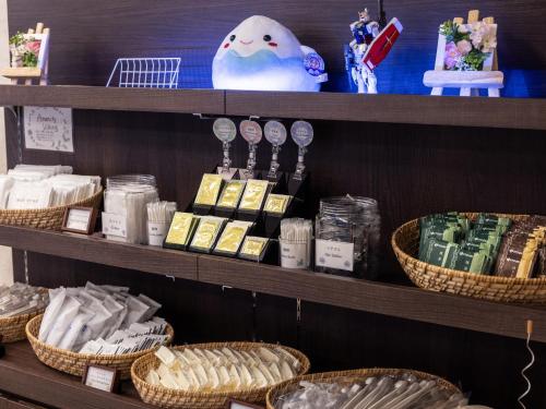 a store shelf with baskets of food and other items at Hotel Wing International Shizuoka in Shizuoka