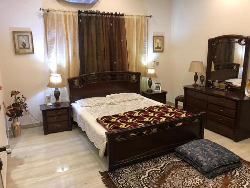 - une chambre avec un grand lit et un miroir dans l'établissement MJS Entire New Designer House, 5 BR, 13 bed, 2 living, reclining sofas, Italian kitchen, 6 bath, garage, side garden at prime location of Bahria Town, Islamabad, à Rawalpindi