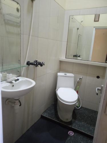 a bathroom with a toilet and a sink at Riki Guesthouse Syari'ah in Jepara