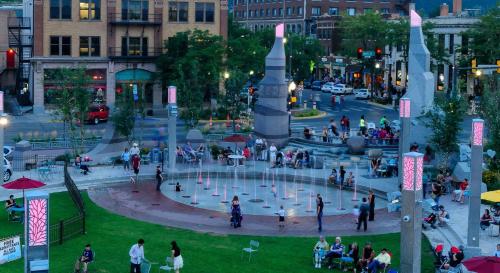 a group of people walking around a fountain in a city at Staybridge Suites Rapid City - Rushmore by IHG in Rapid City