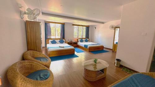 a living room with chairs and a couch and a table at HOTEL ARMS near SUMI Boys School in Kalimpong