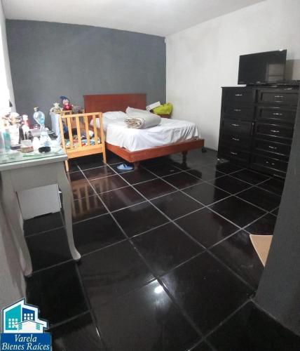 a bedroom with a bed and a black tile floor at Black House in Silao