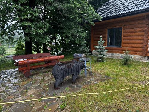 a statue of a bear in front of a cabin at Chalet PidStromom in Mykulychyn