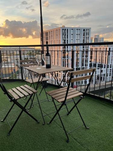 - une table avec 2 chaises et une bouteille de vin sur le balcon dans l'établissement Entire Flat with balcony, à Londres