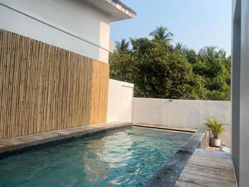 a swimming pool in front of a house at Okat pool villa khanom in Khanom
