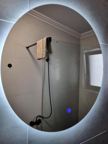 a bathroom with a shower in a round mirror at La Cetate Luxury Apartment in Ipoteşti