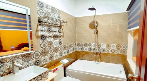 een badkamer met een bad en een wastafel bij Milan Diamond Hotel in Vung Tau