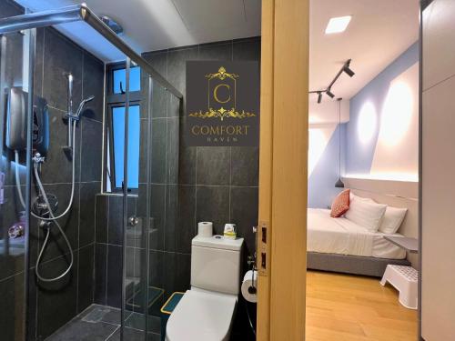 a bathroom with a shower and a toilet and a bed at KLCC Comfort Haven in Kuala Lumpur