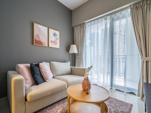 Una sala de estar con un sofá y una ventana grande. en Business Bay's Coziest Hideaway With Balcony, en Dubái