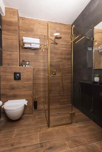 a bathroom with a shower and a toilet and a sink at מלון בוטיק H34 in Nahariyya