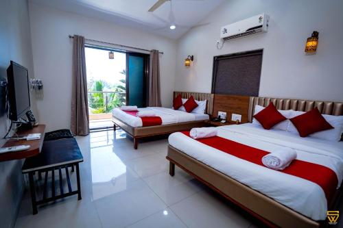 a hotel room with two beds and a television at Lotus The Lake View Resort in Alibaug