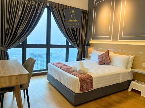 a bedroom with a bed and a desk and a window at KLCC Comfort Haven in Kuala Lumpur