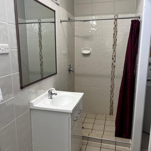 a bathroom with a sink and a shower with a mirror at Jambin hotel motel in Jambin