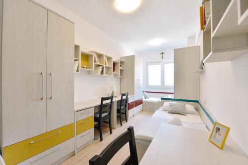 a kitchen with white cabinets and a table and chairs at Hotel Dompes in Mostar