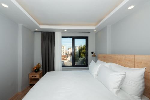 a bedroom with a white bed with a large window at Art Karaköy Suites in Istanbul