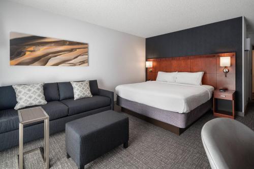a hotel room with a bed and a couch at Courtyard by Marriott Pleasanton in Pleasanton