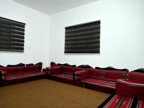 an empty room with red seats in a theatre at رأس منيف /عجلون in Ajloun