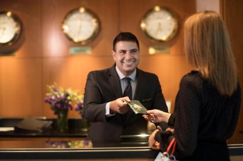 a man and a woman standing at a counter at Le Royal Hotel - Beirut in Beirut