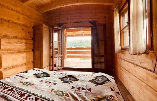 1 dormitorio con 1 cama en una habitación con ventana en Wilk u Drzwi, en Ustrzyki Dolne