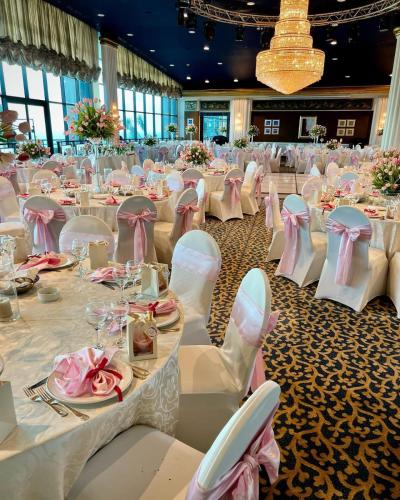 a large banquet hall with white tables and chairs at Le Royal Hotel - Beirut in Beirut