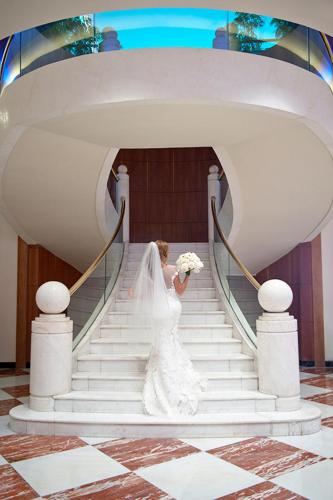a bride walking down the stairs at her wedding at Le Royal Hotel - Beirut in Beirut