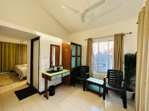 a room with a desk and chairs and a bedroom at Olive Calangute Mira - by Embassy Group in Calangute
