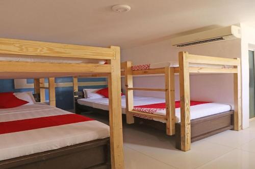 a room with three bunk beds in a house at Villa Tomasa Beach Resort Panglao in Panglao Island