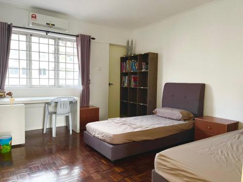 - une chambre avec 2 lits, un bureau et une table dans l'établissement 4BR 9pax in Kuching city, à Kuching