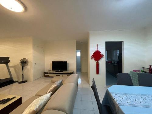een woonkamer met een bank en een tv bij 4BR 9pax in Kuching city in Kuching