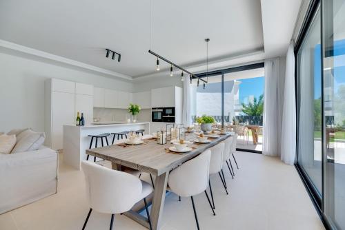 a kitchen and dining room with a wooden table and chairs at VACATION MARBELLA I Villa Monte Halcones, Private-Pool, Brand-New, Incredible Views, Near Golf Valley in Benahavís