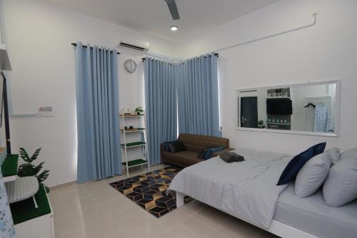 una camera da letto con tende blu, un letto e un divano di Villa De Lova - Wakaf Che Yeh a Kota Bharu