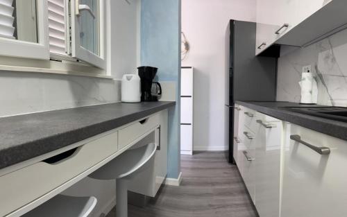a kitchen with white cabinets and a counter top at Apartment Emma in Piran