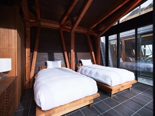 two beds sitting in a room with windows at CAP MARTIN Funny house in Kyonan
