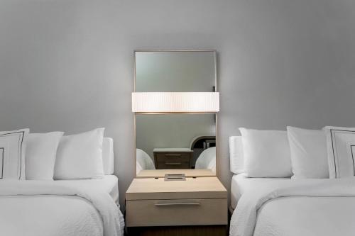 a mirror between two beds in a hotel room at Courtyard Tampa Brandon in Tampa