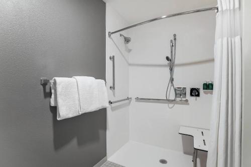 a white bathroom with a shower and towels at Courtyard Tampa Brandon in Tampa