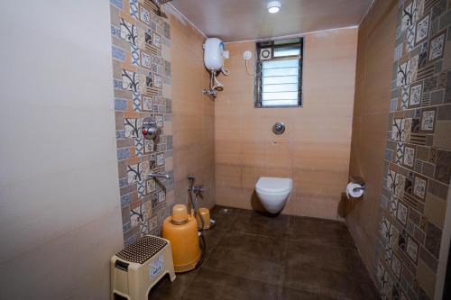 a bathroom with a toilet and a sink in it at Lotus The Lake View Resort in Alibaug