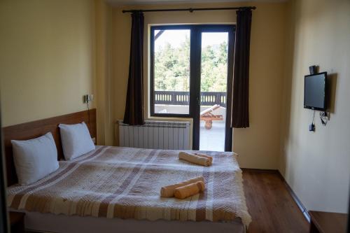 a bedroom with a bed with two towels on it at Rusaliite Adventure House in Bachevo