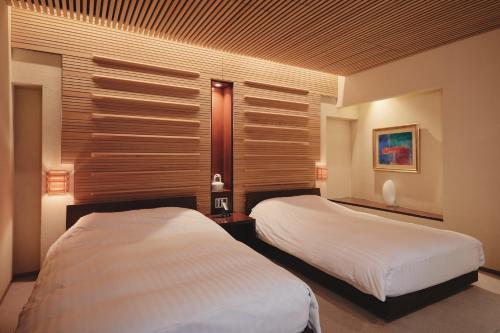 a bedroom with two beds and a window at River Retreat Garaku in Toyama