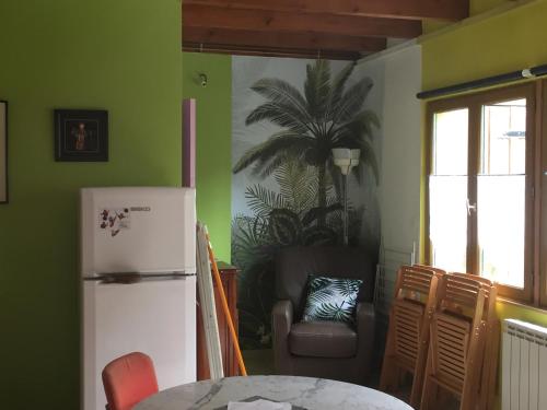 eine Küche mit einem weißen Kühlschrank und einem Stuhl in der Unterkunft La maisonnette in Les Andelys